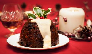 CHRISTMAS PUDDING WITH TRINKETS BURIED IN IT